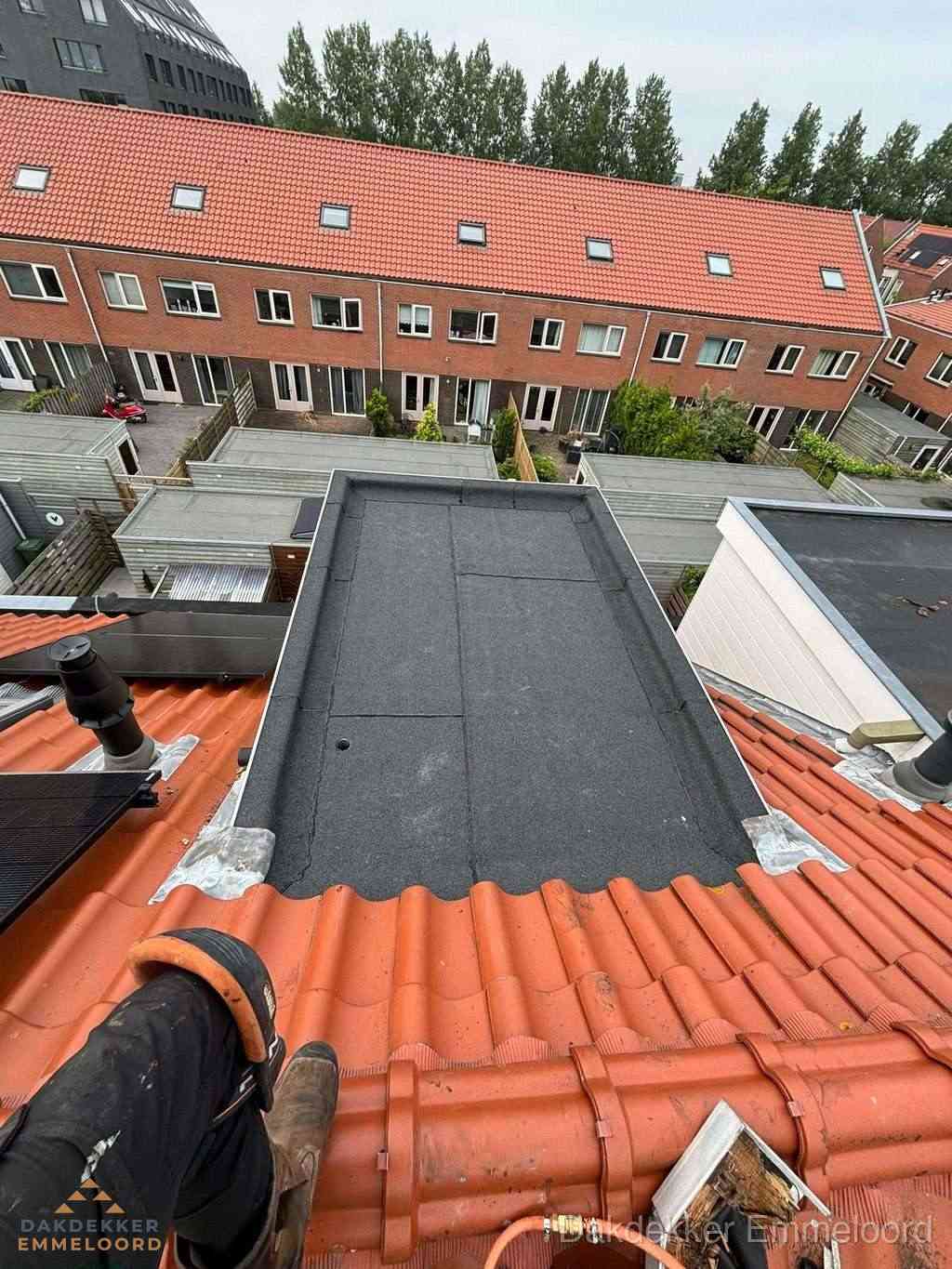 Bitumen dak reparatie op plat dak tussen dakpannen in Emmeloord