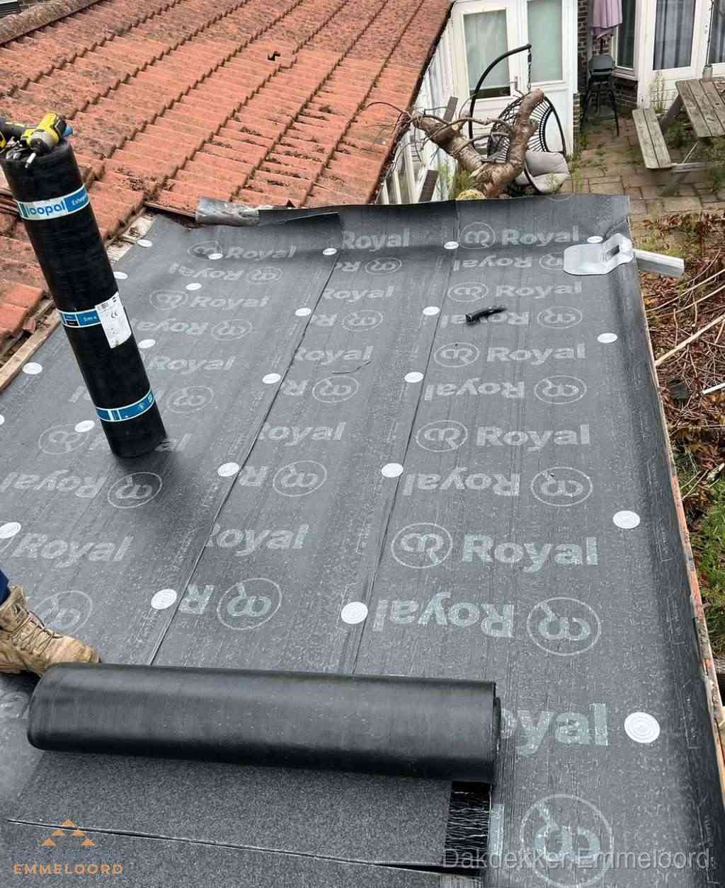 Plat dak met nieuwe bitumen dakbedekking en brandgereedschap in Emmeloord