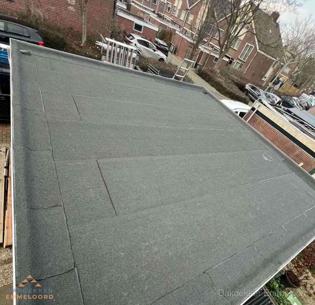 Nieuwe bitumen dakbedekking op plat dak van garage in Emmeloord