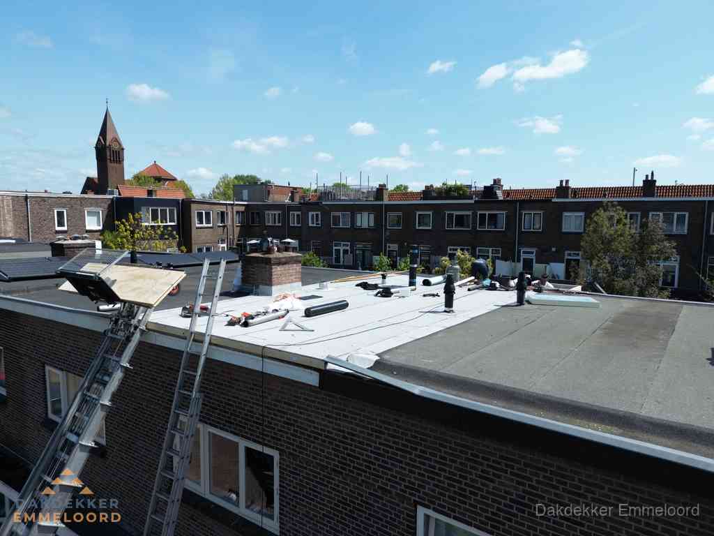 Dakdekkers aan het werk op plat dak in Emmeloord