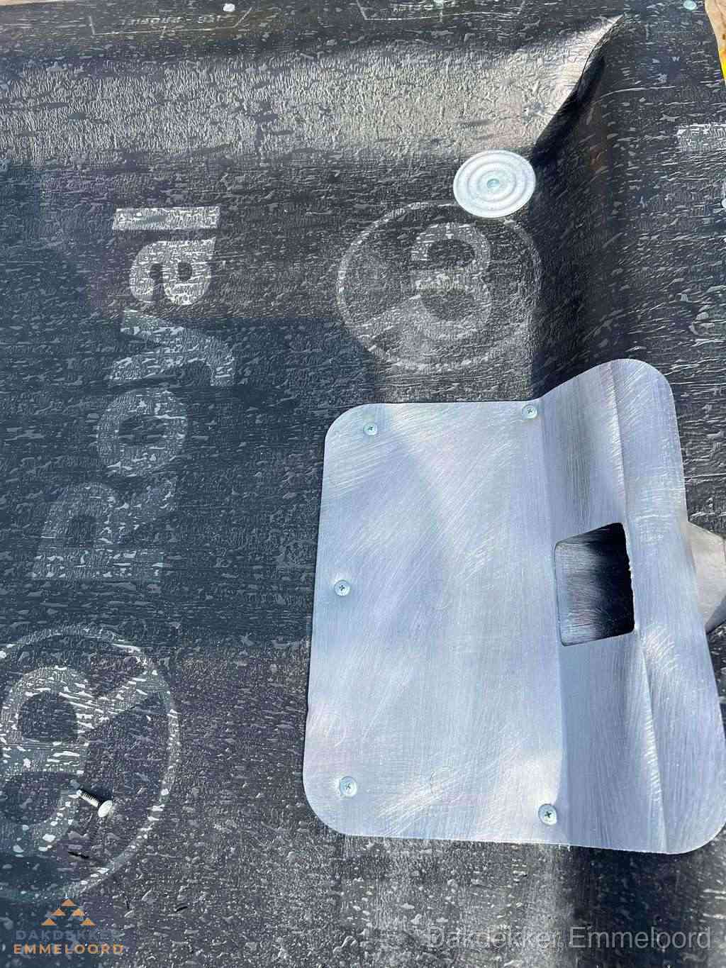 Dakdoorvoer met metalen afvoerplaat op bitumen dak in Emmeloord