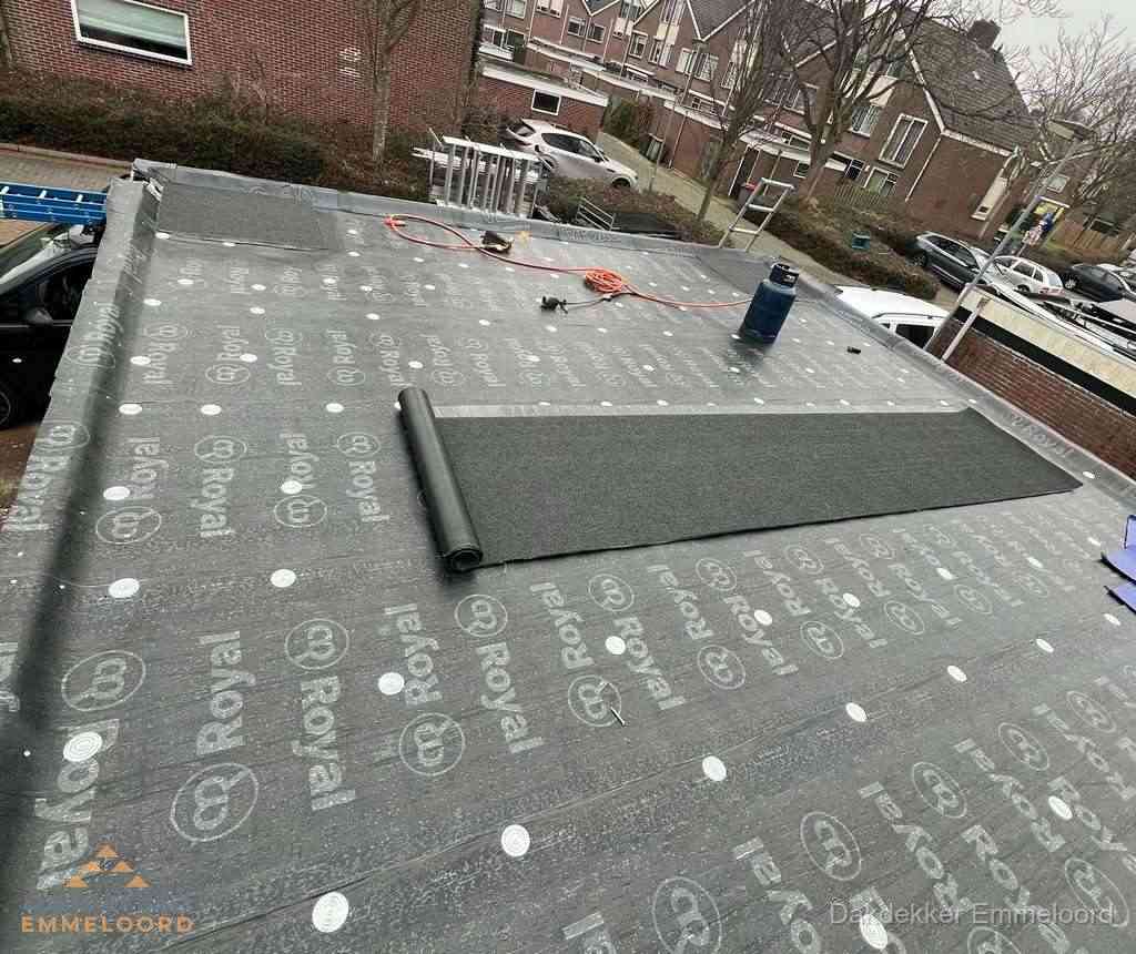 Dakdekker aan het werk met gasbrander op plat bitumen dak in Emmeloord