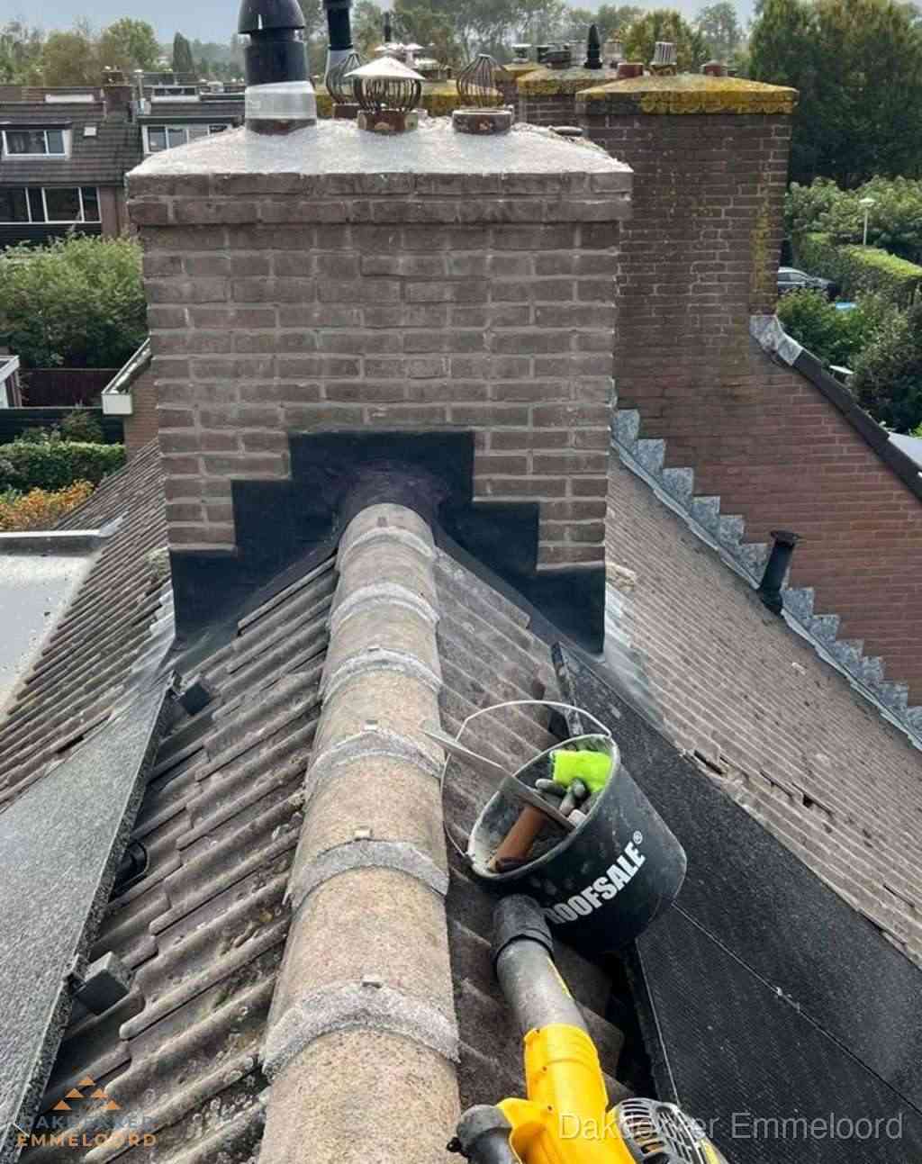 Dakdekker repareert bitumen dakleer bij dakdoorvoer in Emmeloord
