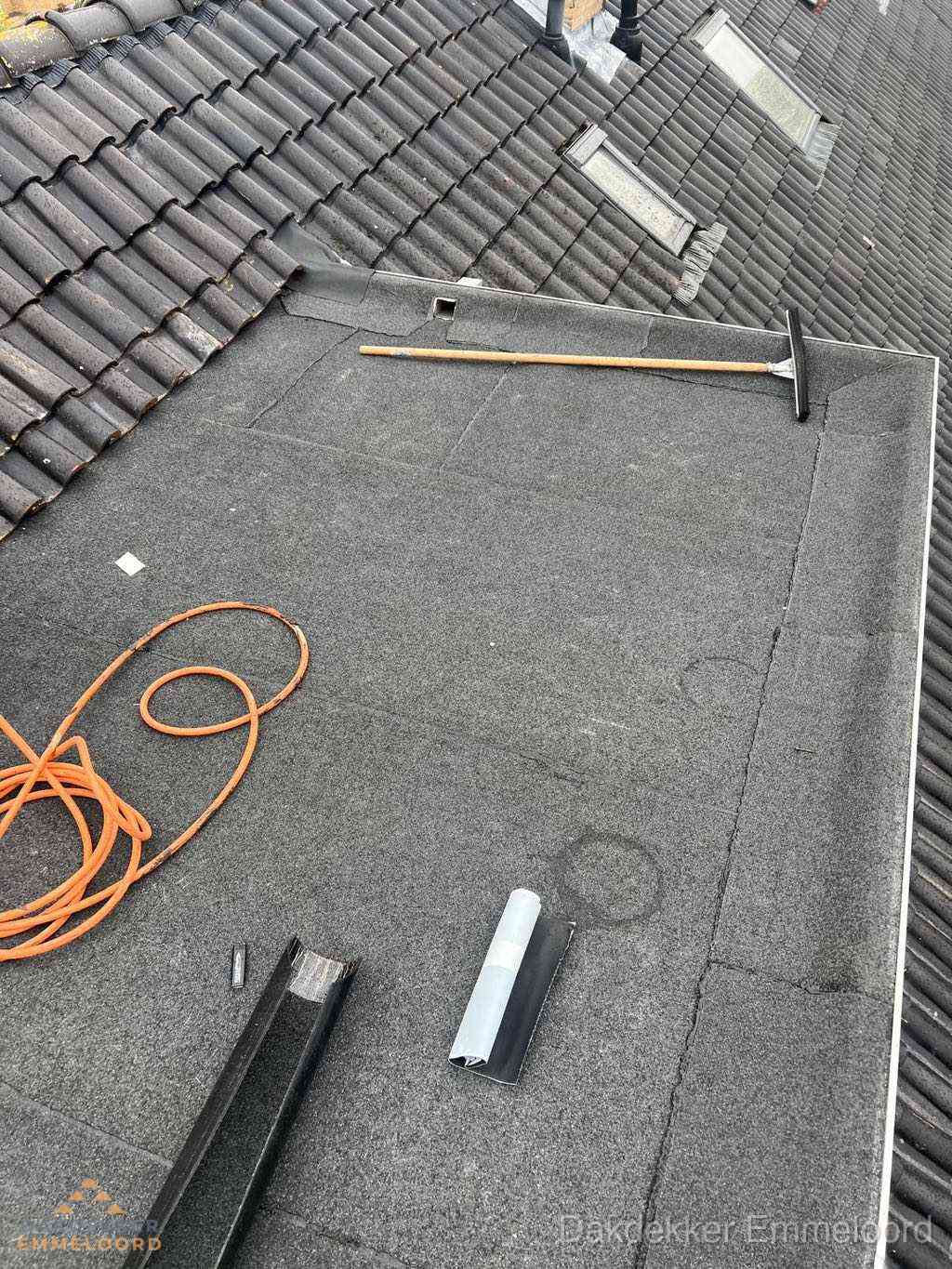 Plat dak reparatie met gereedschap en loodstroken in Emmeloord