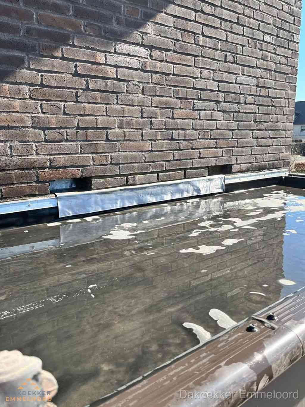 Stilstaand water op plat dak door slechte afwatering in Emmeloord