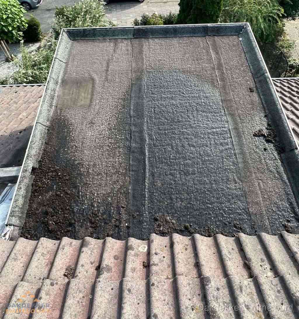 Verouderd plat dak met bitumen en slijtage voor lekkage inspectie in Emmeloord